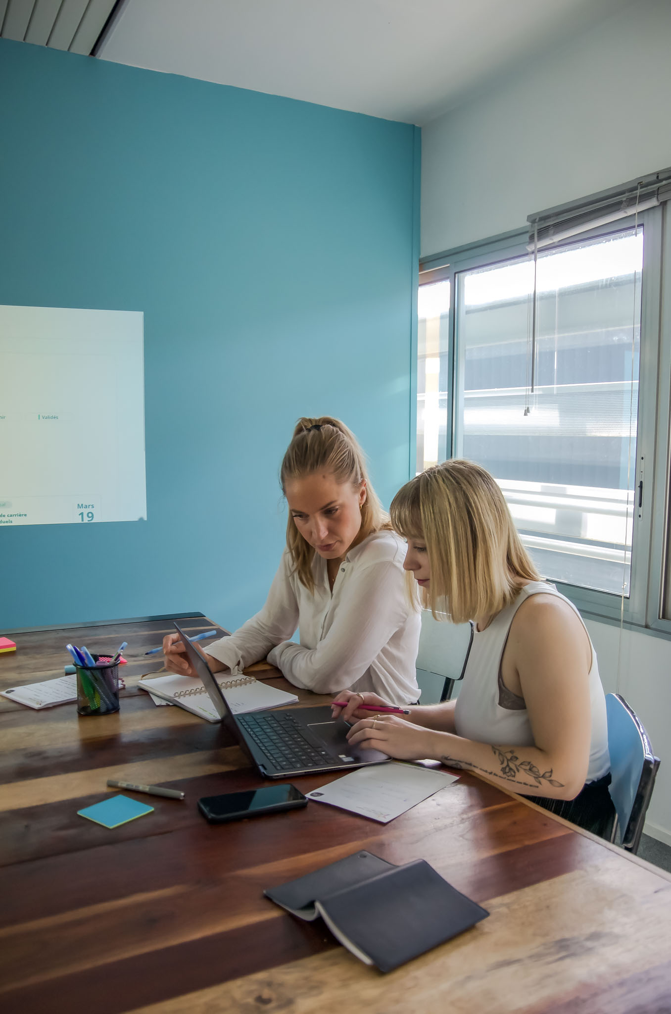Deux membres de l'équipe Doddee au travail devant un ordinateur.